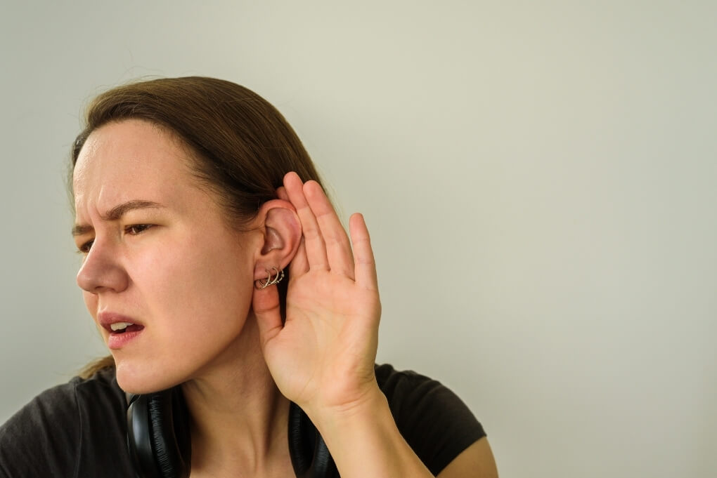 Woman experiencing hearing changes associated with Meniere's disease symptoms