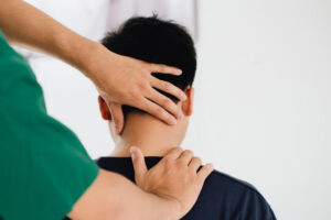 Physiotherapist assessing neck muscles and headaches during a physiotherapy treatment session