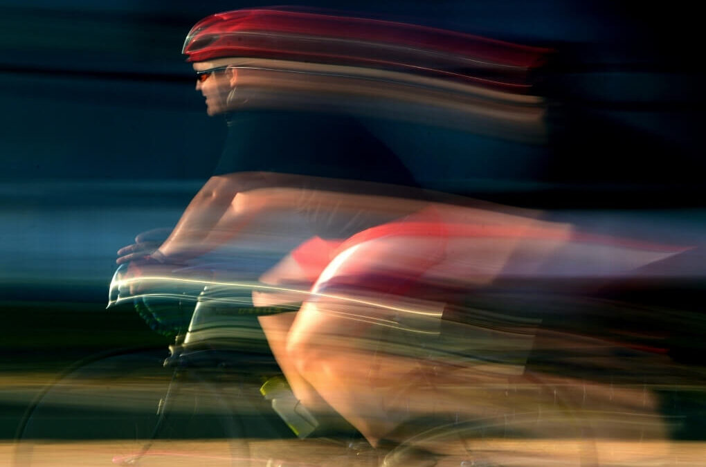 Cyclists captured with strong motion blur, illustrating visual motion sensitivity and the fast-moving visual input that may trigger migraine symptoms.