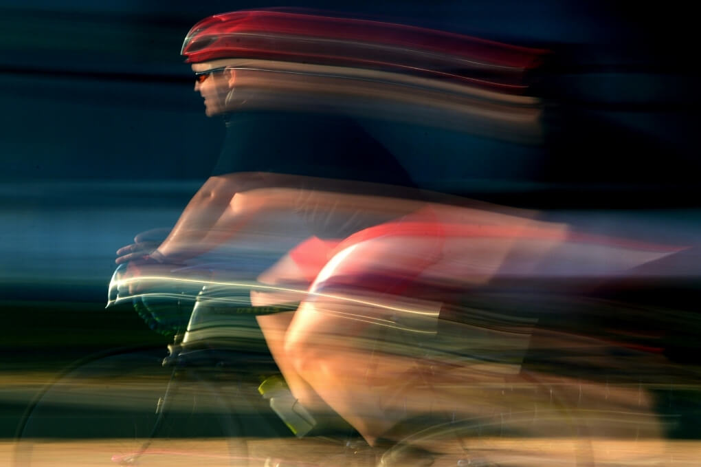 Cyclists captured with strong motion blur, illustrating visual motion sensitivity and the fast-moving visual input that may trigger migraine symptoms.