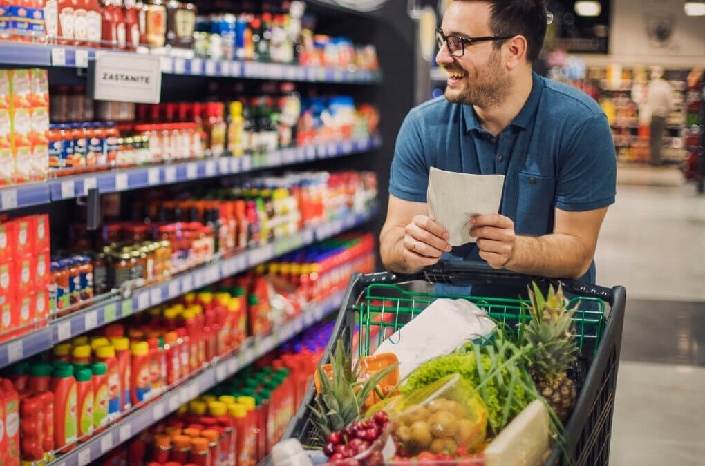 Man shopping in a colourful supermarket aisle, representing the visual, movement and decision-making demands involved in migraine sensory overload.