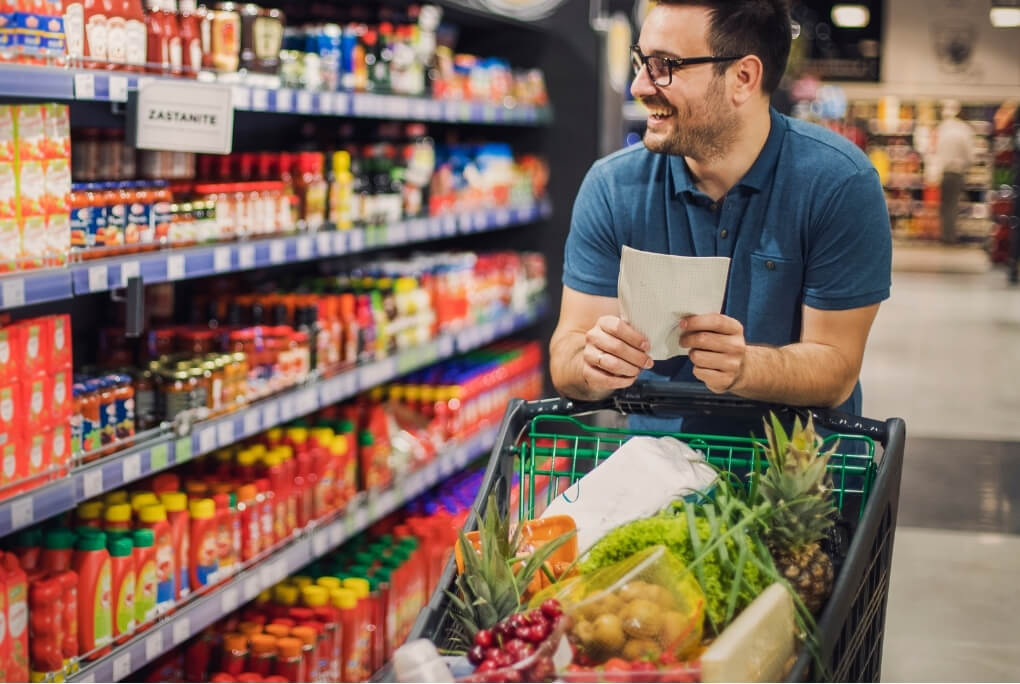Man shopping in a colourful supermarket aisle, representing the visual, movement and decision-making demands involved in migraine sensory overload.