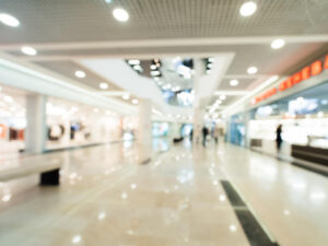 Bright and visually busy shopping centre interior representing the environmental demands associated with migraine sensory overload.