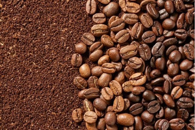 Coffee beans and ground coffee symbolising caffeine and headaches connection.