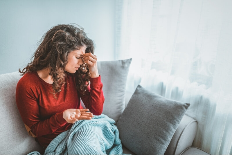 Woman taking medication for headache in pain