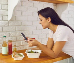 Woman tracking food and symptoms, illustrating how diet links to the gut-brain connection and headaches.