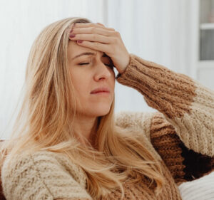Woman holding her head in frustration, representing headaches with normal scans despite ongoing pain