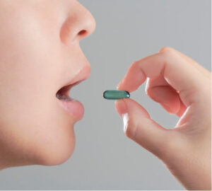 Close-up of person taking a painkiller, highlighting the issue of medication overuse headache.